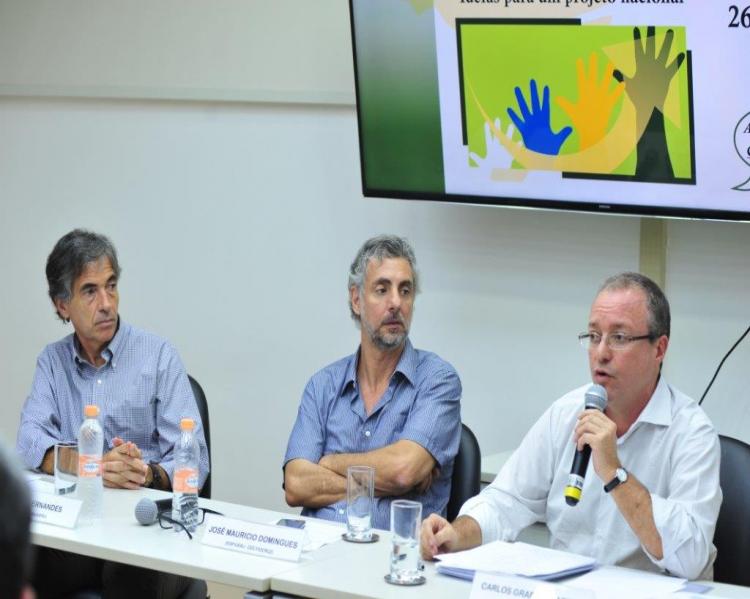 Luis Fernandes, José Maurício Domingues e Carlos Gadelha (três hons sentados em uma mesa de debates, o da ponta direitaao microfone e os demais observando)