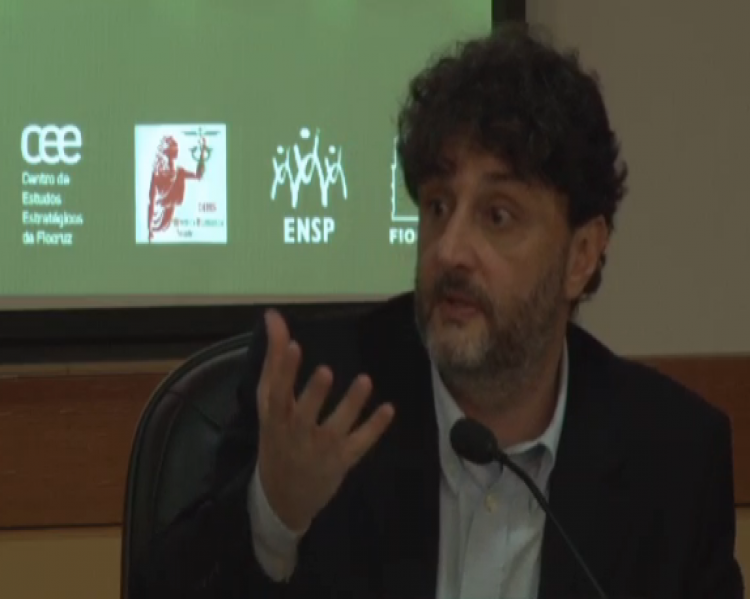 Salo de carvalho, homem de paletó preto, gesticulando com as mãos enquanto fala ao microfone. 