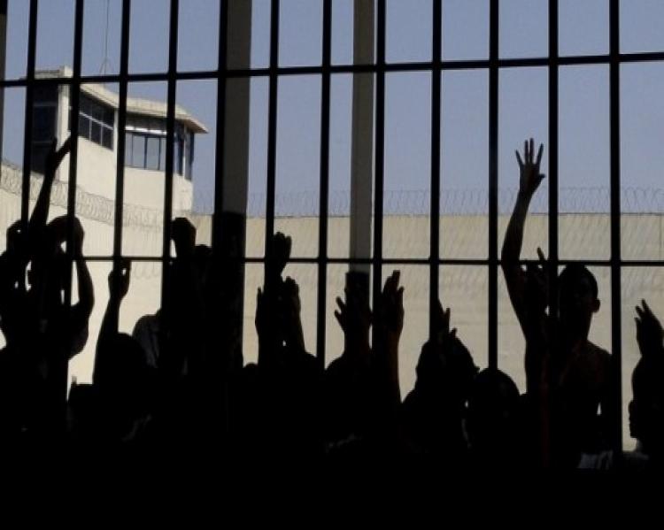 Silhuetas de pessoas e mãos segurando grades