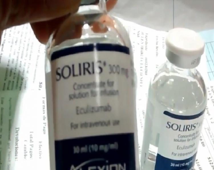 Frasco de medicamento em primeiro plano, com rótulo Soliris virado para frent