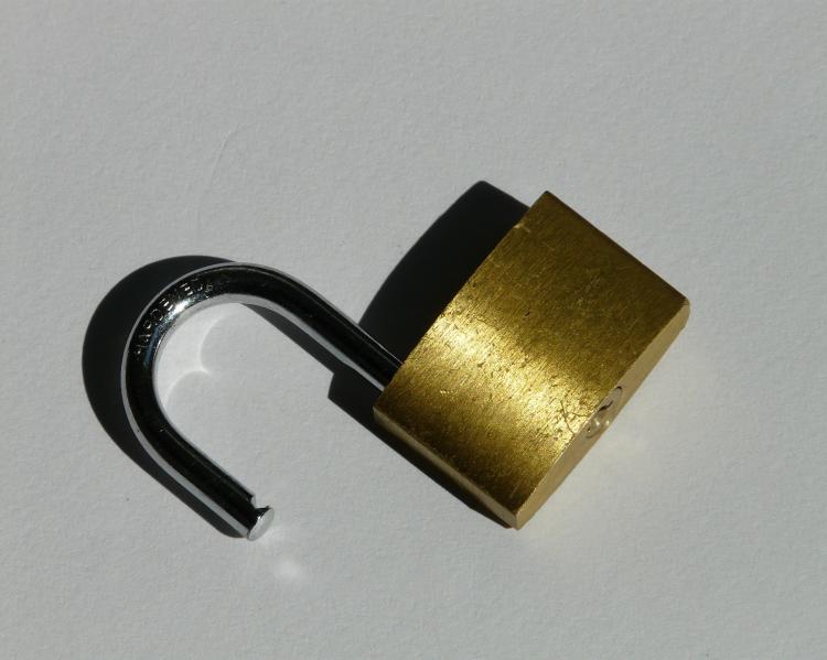 Cadeado prateado aberto sobre fundo cinza