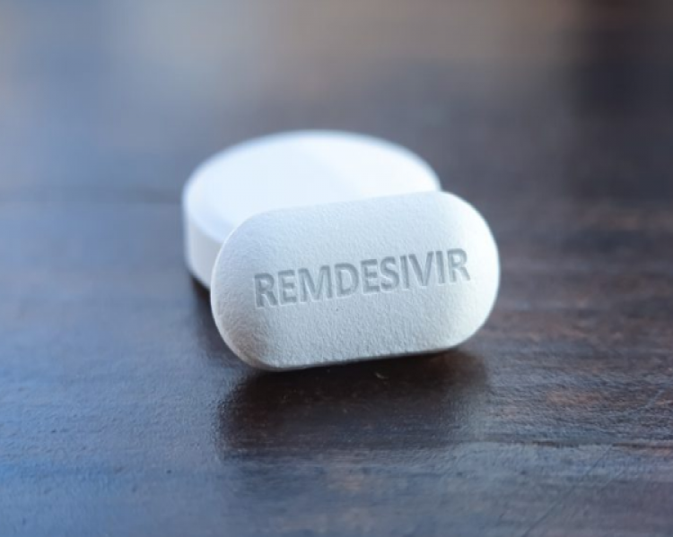 Dois comprimidos de cor branca sobre superfície escura