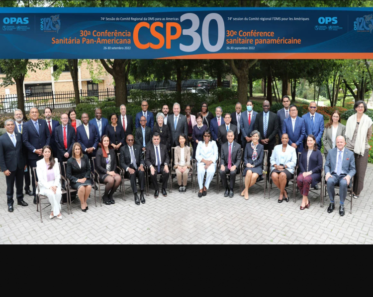 Homens e mulheres reunidos, alguns sentados à frente, outros de pé, atrás, tendo acima da imagem uma faixa de fundo azul onde se lê CSP30