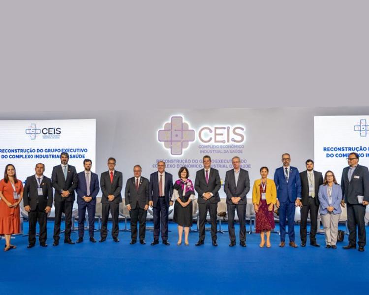 Homens e mulheres de pe, sobre um palco azul