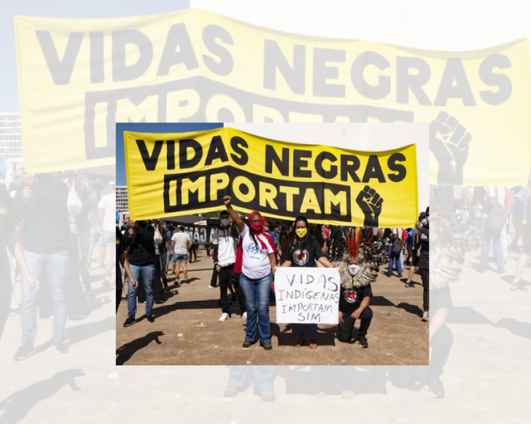 Mulheres e homens em uma manifestação levantam uma enorme faixa amarela onde está escrito em letras pretas Vidas negras importam