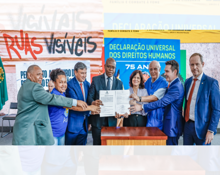 Homens e mulheres seguram e mostram um documento, tendo atrás deles a logomarca Ruas Visíveis